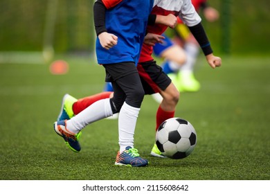 Children Kicking Soccer Ball On Grass Field. Two School Kids Running In A Duel And Compete In Football Game