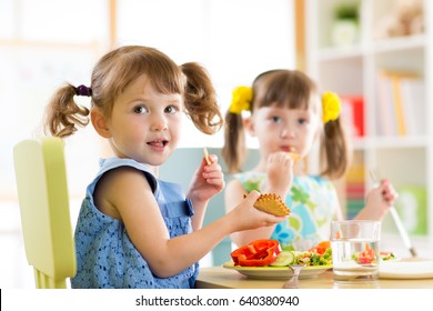 Children Kids Eating From Plates In Day Care Centre