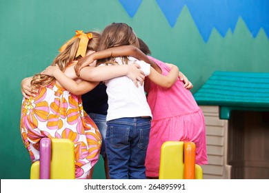 Children in kindergarten going into huddle to hold a council of war - Powered by Shutterstock