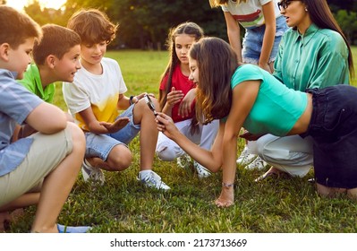 Children Learning About Nature. Group Of Kids Having Fun Biology Class Outdoors. Schoolkids, Classmates And Friends Together With Teacher Sitting On Green Meadow Studying Bugs Through Magnifying Glass