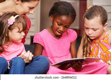 Children Learning To Read With Nursery Teacher In Preschool