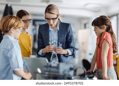 Children learning robotics in Elementary school. Young students building robot in after school robotics club. Field trip to real robotics laboratory. - Powered by Shutterstock