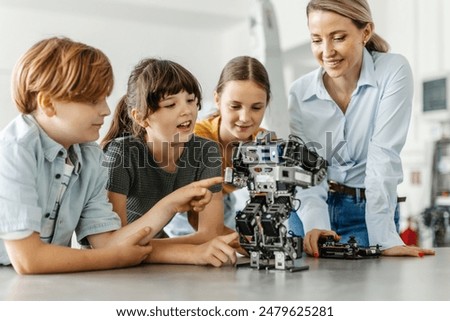 Children learning robotics in Elementary school. Young students building robot in after school robotics club. Field trip to real robotics laboratory.