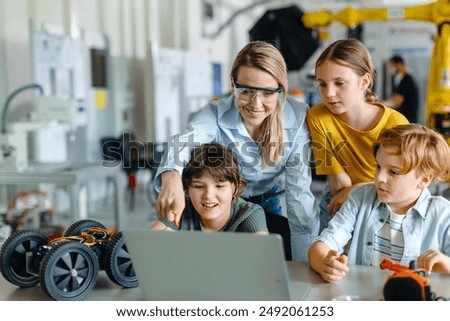 Children learning robotics in Elementary school. Young students programming, building robot in after school robotics club. Field trip to real robotics laboratory.