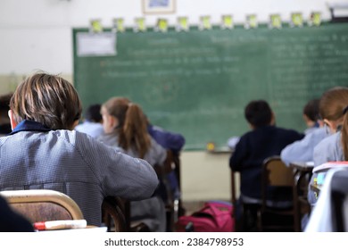 Children learning at school. Primary school students in classes. Students in class at a Catholic school. Boys at their desks dressed in uniform. Education. - Powered by Shutterstock