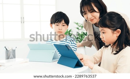 Children learning from a teacher with tablet PC.