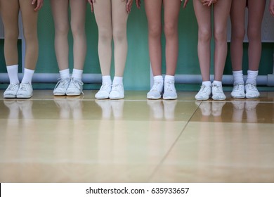 Children Legs Of Aerobic Athletes Wearing In White Sport Boots Standing In Line In Gym