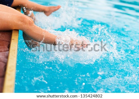 Children legs in the water splashing
