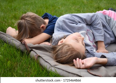 children lie on the mattress outsite. Boy and girl sleeping on the grass. Summer holidays in the fresh air. The outdoor - Shutterstock ID 1725464866