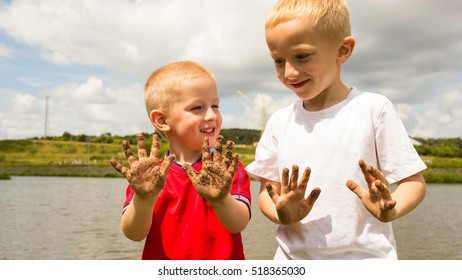 Children Little Blonde Boys Kids Playing Outdoor Showing Dirty Muddy Hands. Happy Childhood.