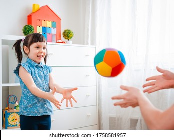 Children Little Girl Play In A Children's Game Room, Throwing Ball. Concept Of Interaction Parent And Kid, Communication, Mutual Play, Quarantine, Self-isolation Home, Education.