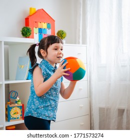 Children Little Girl Play In A Children's Game Room, Throwing Ball. Concept Of Interaction Parent And Kid, Communication, Mutual Play, Quarantine, Self-isolation Home, Education.