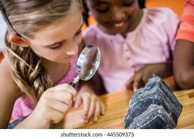 Children looking fossils with a magnifying glass at school - Powered by Shutterstock