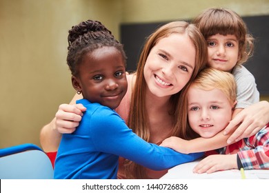 Children Lovingly Embrace Their Kindergarten Teacher In The Kindergarten Or Daycare