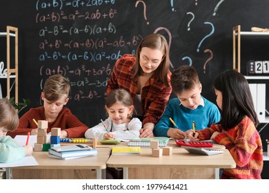Children With Math Teacher During Lesson In Classroom
