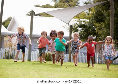 Children At Montessori School Having Fun Outdoors During Break