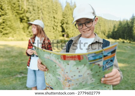 Children navigating with a map during a hike, enjoying a forest adventure during their family vacation