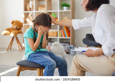 Children Need Help. Little Girl Crying In Psychologist's Office Sharing Her Problems. Professional Psychotherapist Talking To Hurt Child, Consoling, Comforting, Dealing With Psychological Trauma