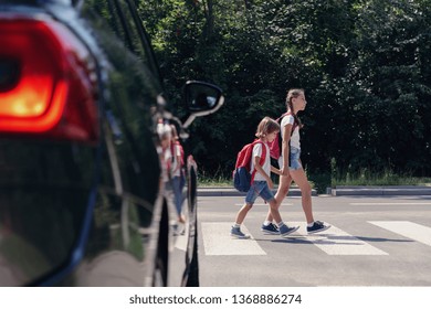 Children next to a car walking through pedestrian crossing to the school - Shutterstock ID 1368886274