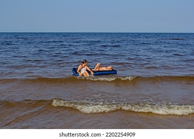 Children On An Air Mattress On The Water