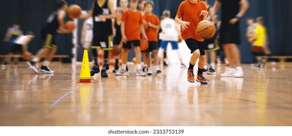 Children on basketball training. Group of school boys practicing basketball with a young coach. Kids play sports during a basketball training drills on a wooden court - Powered by Shutterstock