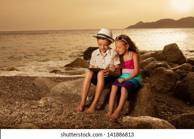 Children On The Beach With Tablet Computer.