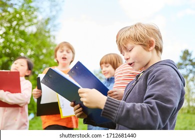 Children On A Treasure Hunt Or Scavenger Hunt With Clipboard In Nature