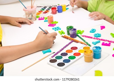 Children paint with gouache, paints , pencils. Mobile and entertainment Board games for children.Ceramic dishes in working process. Creating color patterns.