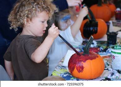 Children Are Painting Pumpkins At A Fall Party 