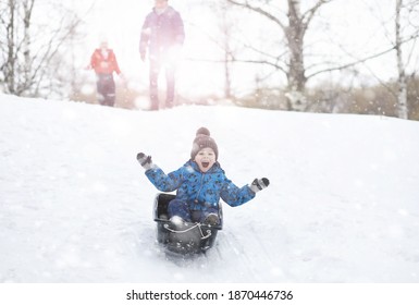 Children In The Park In Winter. Kids Play With Snow On The Playground. They Sculpt Snowmen And Slide Down Hills.