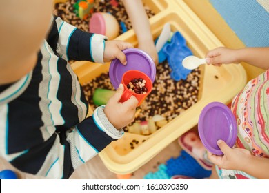 Children Play Educational Games With A Sensory Bin In Kindergarten