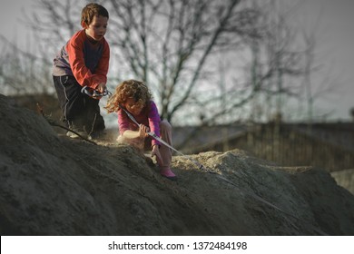 Children Play On The Hill Of Mud With A Dog