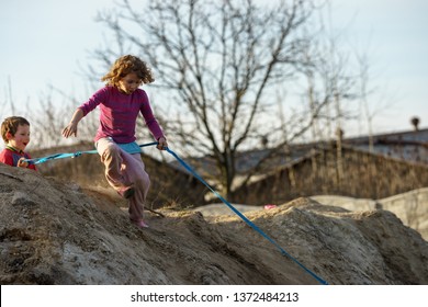 Children Play On The Hill Of Mud With A Dog