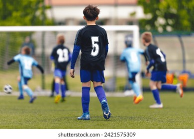 Children Play Outdoor Sport on a Sunny Day. School Soccer Boys Playing Tournament Match. Soccer Players Compete on Sports Grass Field. School Boy in Black Soccer Jersey Shirt With White Number on Back - Powered by Shutterstock