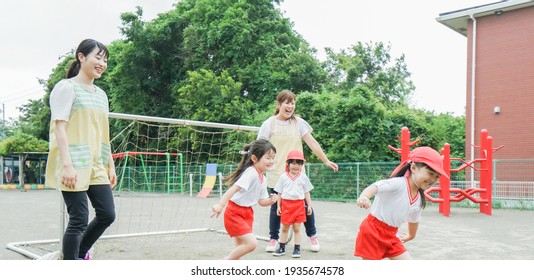 Children Play Outside At Nursery School