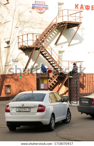 children play outside; they climbed the fence.\
On the wall is a metal staircase for evacuation. Minsk, Republic of\
Belarus. 27.03.2020