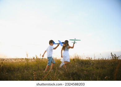 children play toy airplane. concept of happy childhood. children dream of flying and becoming a pilot - Powered by Shutterstock