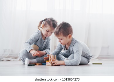 Children play with a toy designer on the floor of the children's room. Two kids playing with colorful blocks. Kindergarten educational games.