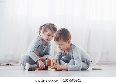 Children play with a toy designer on the floor of the children's room. Two kids playing with colorful blocks. Kindergarten educational games. - Shutterstock ID 1017595261