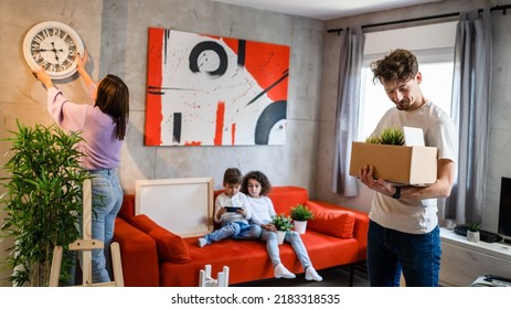 Children Play Video Games On Mobile Phone While Parents Take Personal Stuff Moving In New Apartment Real People Copy Space Caucasian Man And Woman With Siblings