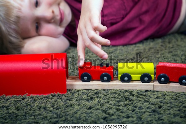 Children play with\
wooden toy, build toy railroad at home or daycare. Toddler boy play\
with  train and cars. Educational toys for preschool and\
kindergarten child. 