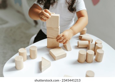 children play with wooden toys in the children's room - Shutterstock ID 2345441213