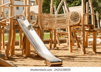 Children Playground with Modern Swing Slide Wooden Climbing Equipment in Play Area. Entertainment Park for Kids in Nature. - Powered by Shutterstock