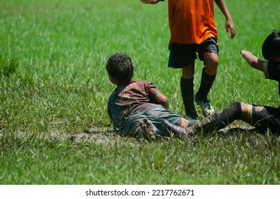 Children Playing Ball On A Muddy Field