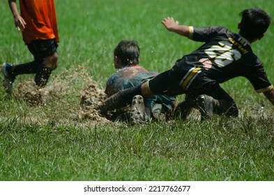 children playing ball on a muddy field