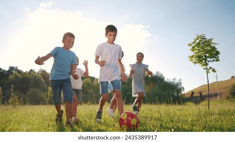 children playing ball in the park. group of children playing ball at sunset in nature. happy family kid dream concept. children playing soccer in the lifestyle park in nature - Powered by Shutterstock