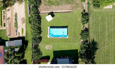 Children Playing In A Beautiful Pool, Overhead Aerial View.