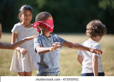 Children playing blind man's buff in summer and having fun