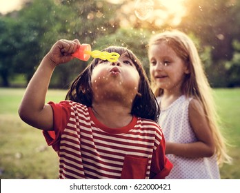 Children is playing bubbles in a park