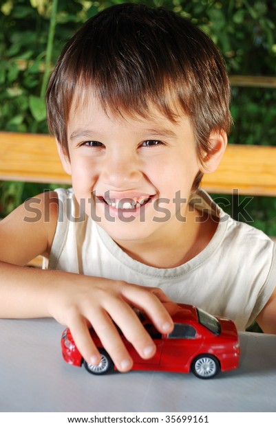 Children\
playing with cars toys outdoor in summer\
time